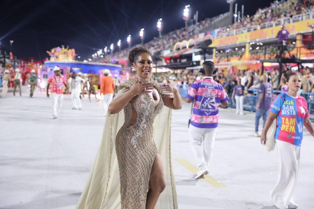 Carnaval RJ - Valéria Valenssa de vestido prata, com capa transparente, desfilando na Sapucaí